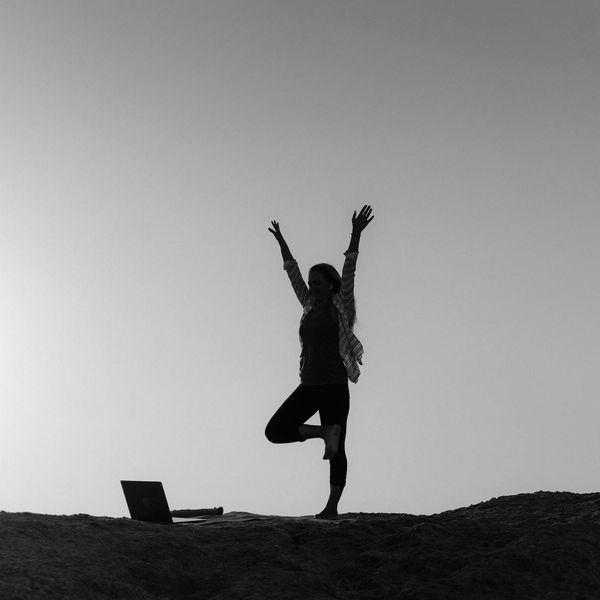 Silhouette of a person stretching during sunrise.